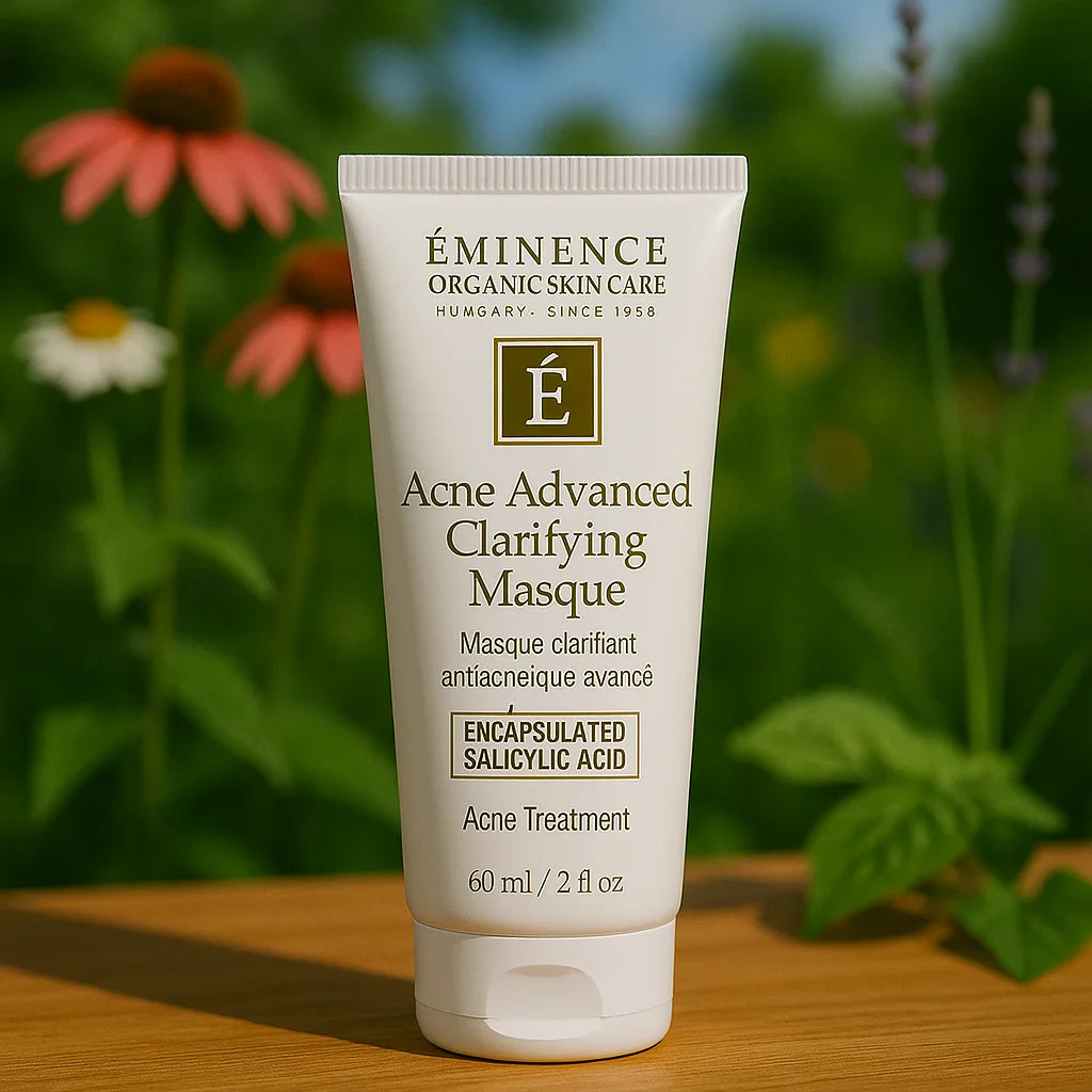 Éminence Organic Skin Care Acne Advanced Clarifying Masque potje, op een houten ondergrond met een bloemrijke achtergrond.