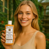 Een persoon die het Éminence Organic Skin Care Mangosteen Daily Resurfacing Cleanser flesje vasthoudt, in een natuurlijke buitenomgeving met groen op de achtergrond.