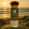 Éminence Organics Sun Defense Minerals Sheer 5 g close-up op een rots aan een zonnige kustlijn, voor gevoelige huid